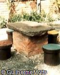 Mesa e assentos em concreto, tijolo e pedra